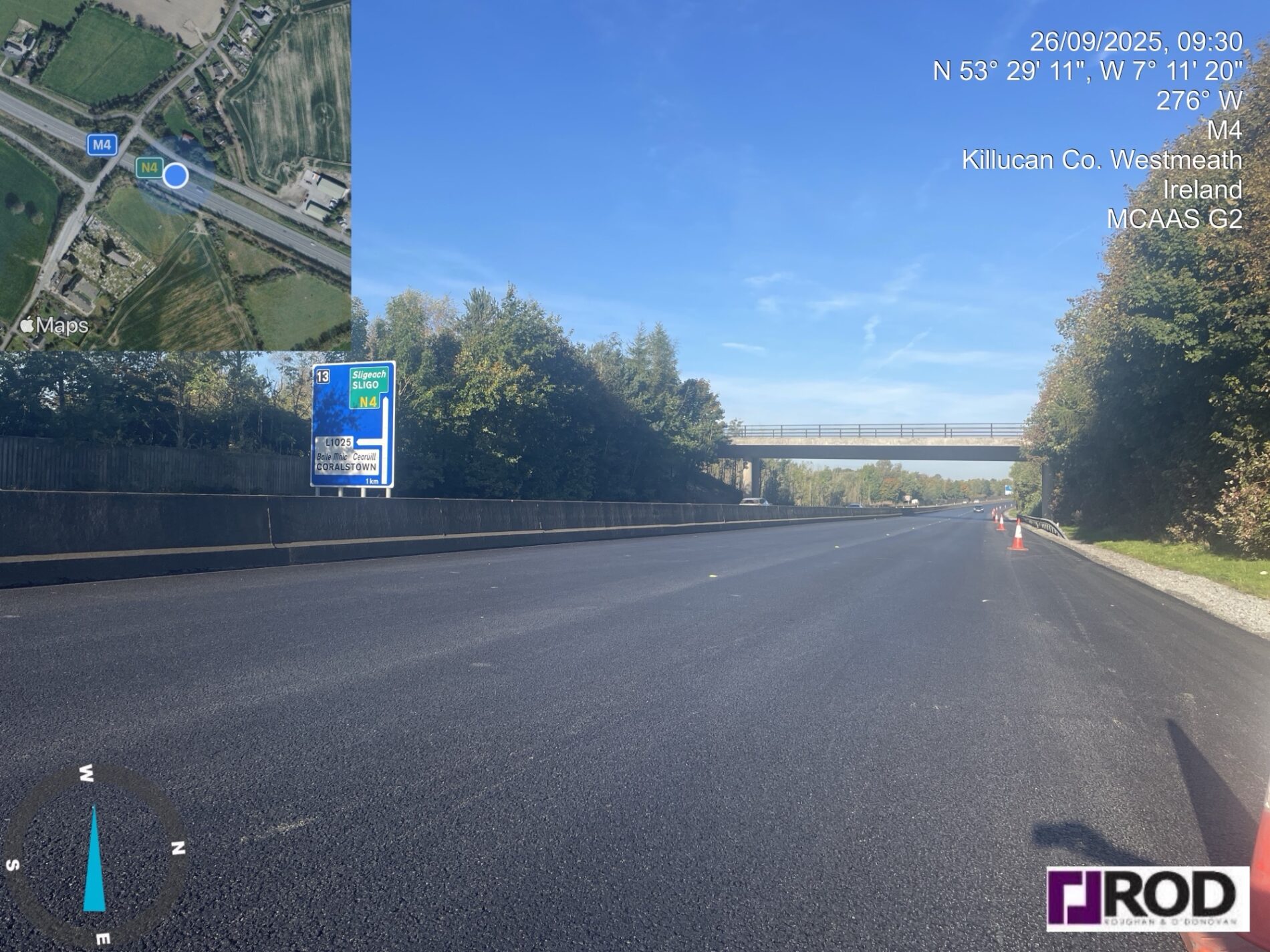 Ground-level view of a freshly resurfaced section of the M4 motorway near Killucan, Co. Westmeath, Ireland, on a clear autumn morning, with traffic cones still in place and a road sign indicating the N4 towards Sligo.